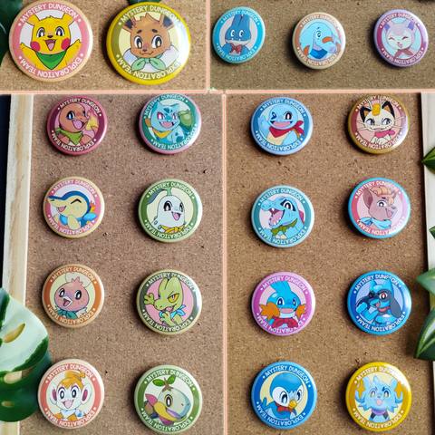 Une vingtaine de badges ronds épinglés sur des tableaux en liège : chaque badge montre un Pokémon souriant avec un foulard, entouré d'un anneau coloré.